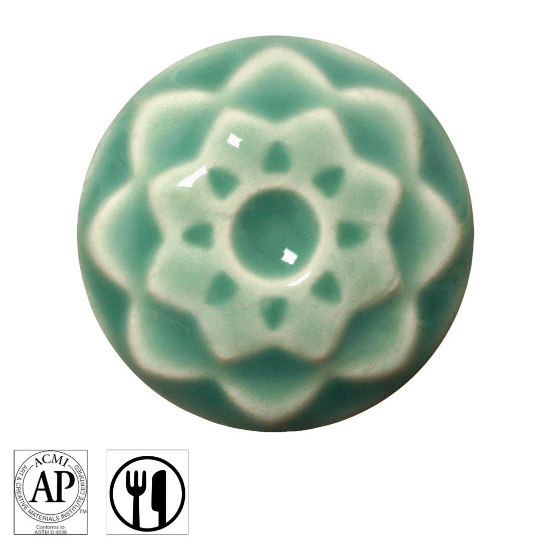 clay chip with Aqua AMACO Celadon High Fire Transparent Gloss Glaze applied; symbols for AP Seal and food safe