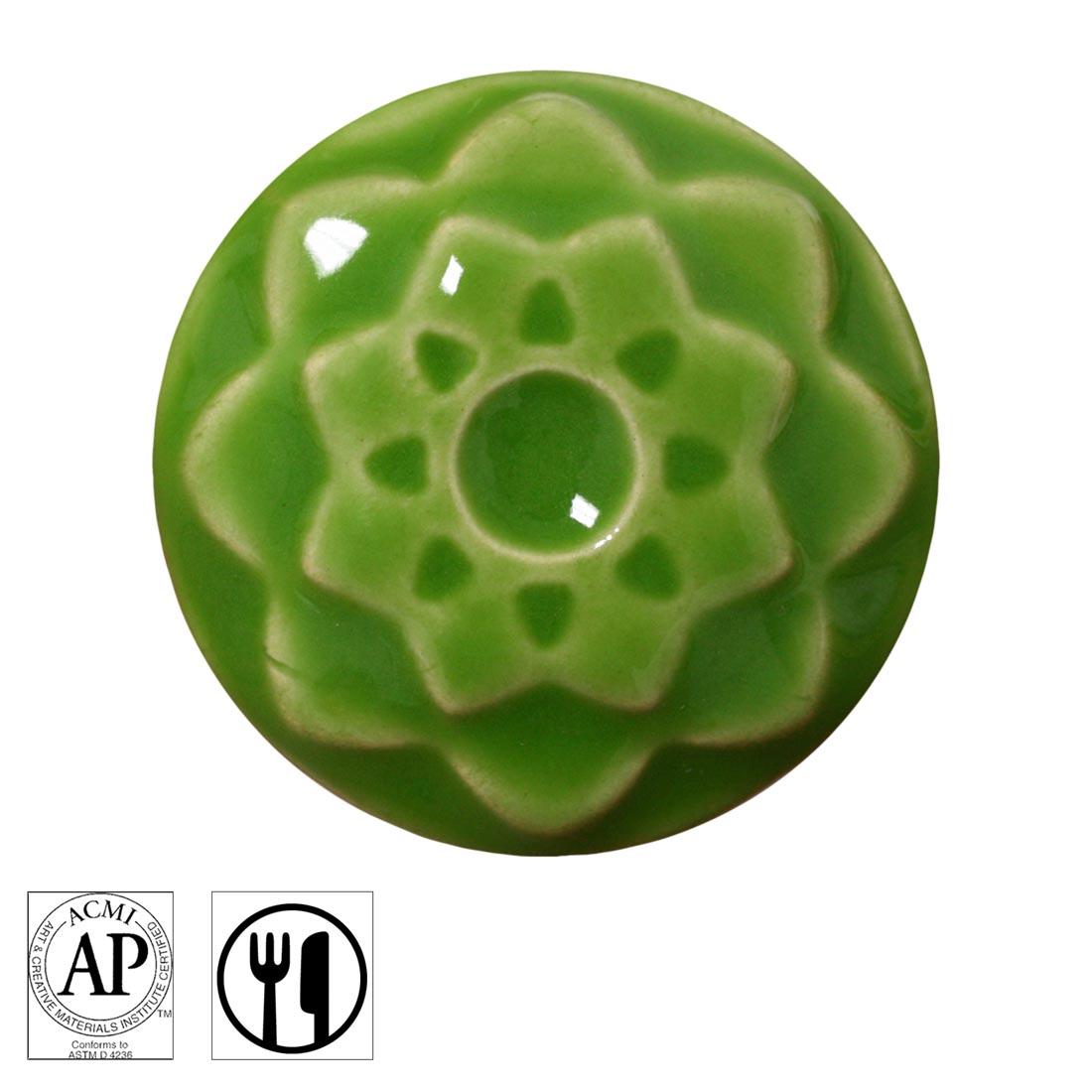 clay chip with Wasabi AMACO Celadon High Fire Transparent Gloss Glaze applied; symbols for AP Seal and food safe