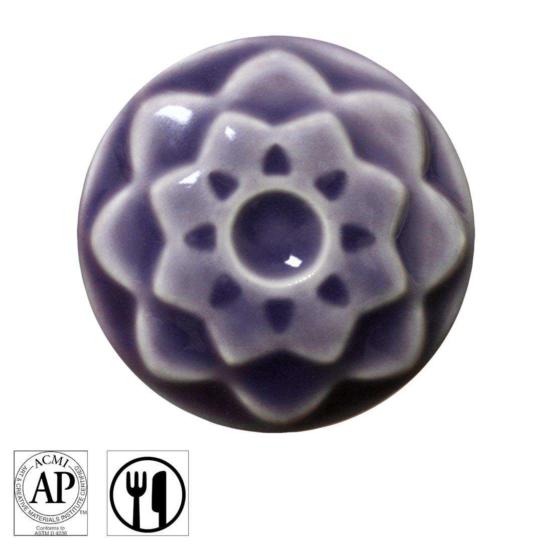 clay chip with Lavender AMACO Celadon High Fire Transparent Gloss Glaze applied; symbols for AP Seal and food safe