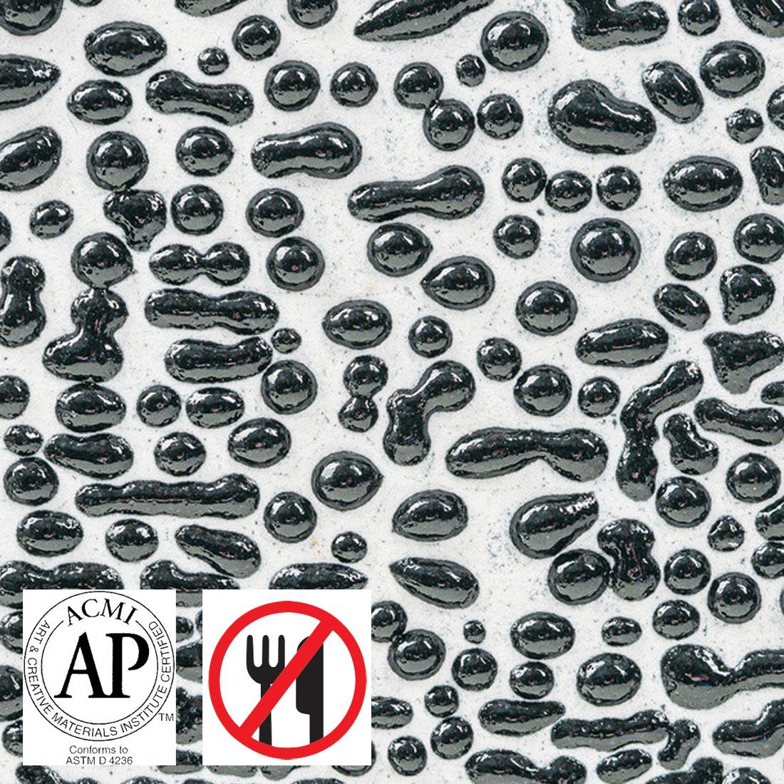 Clay tile with Black AMACO Crawls High Fire Glaze applied plus symbols for AP Seal and not food safe