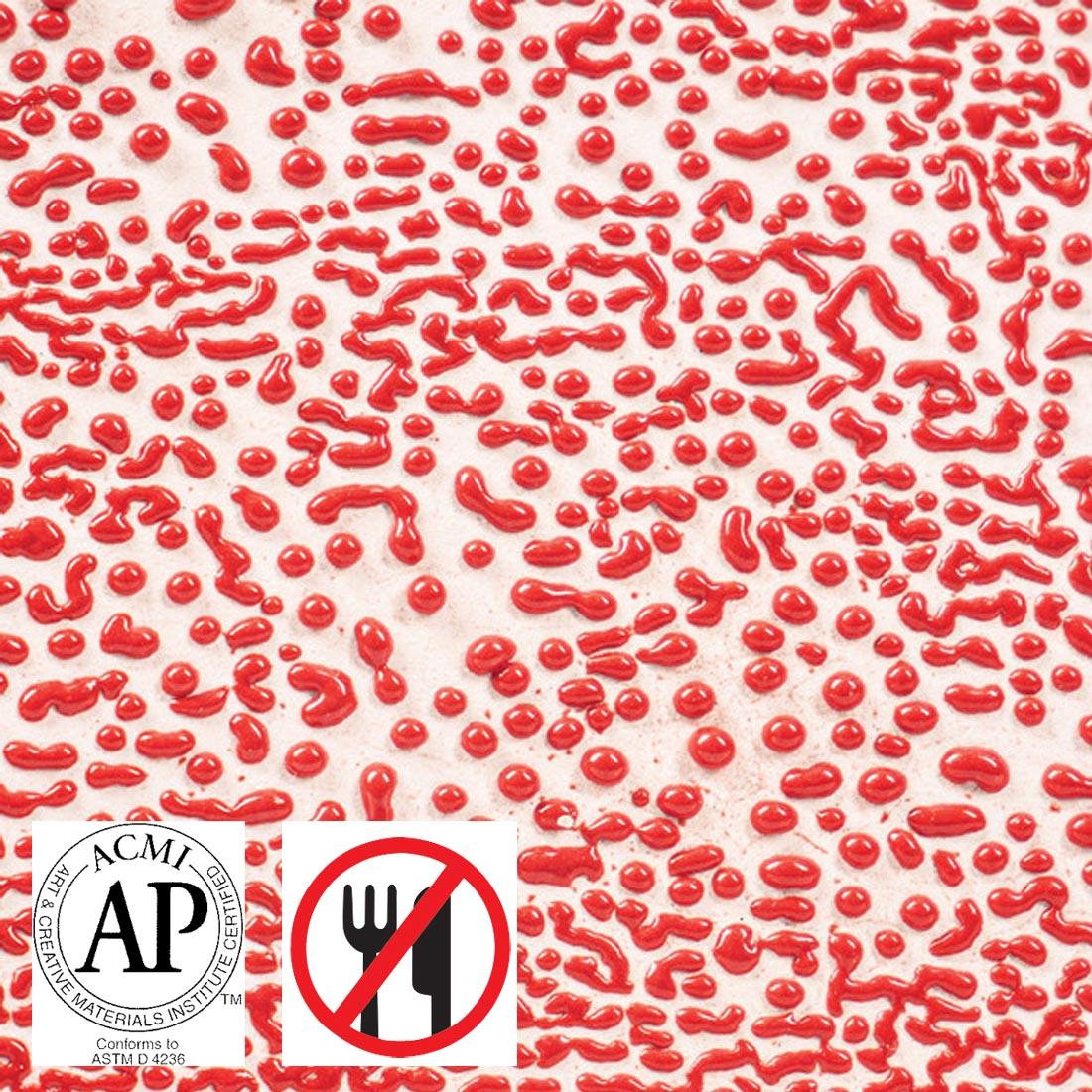 Clay tile with Red AMACO Crawls High Fire Glaze applied plus symbols for AP Seal and not food safe