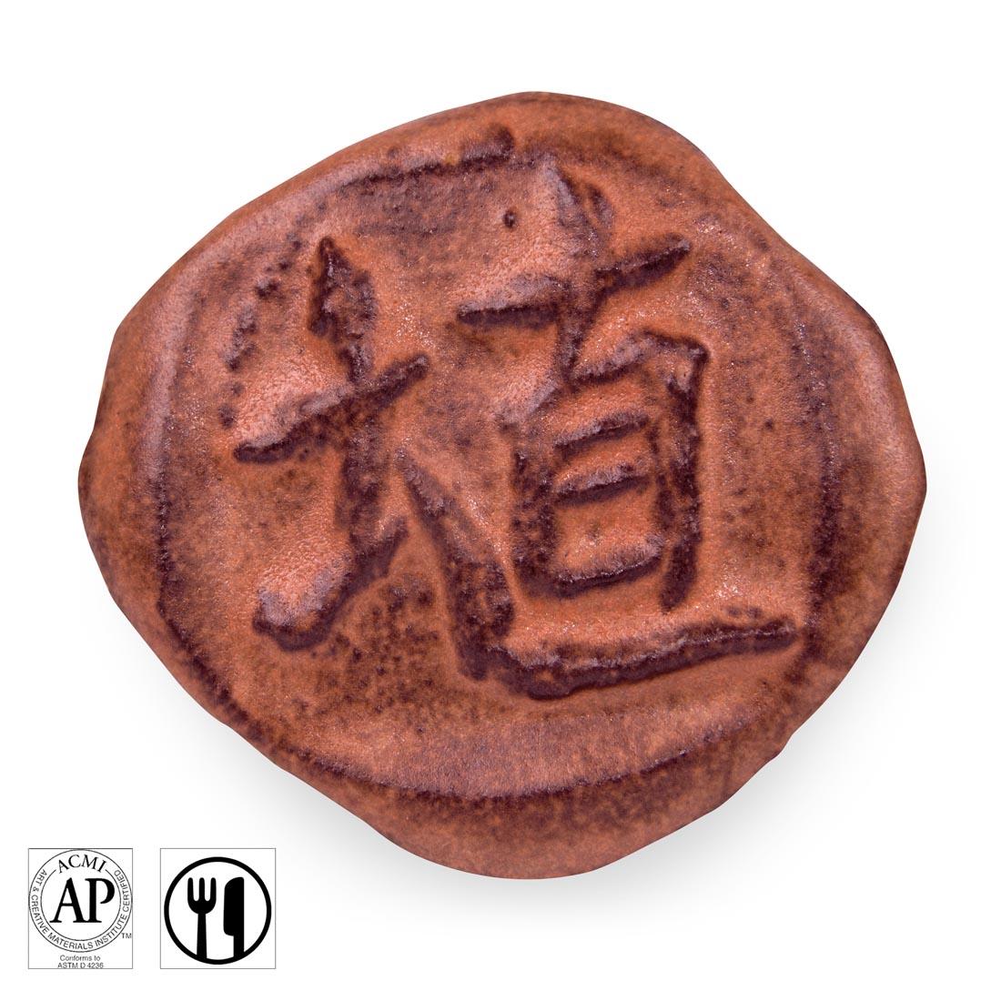 clay chip with Hibiscus Matte AMACO Shino High Fire Glaze applied; symbols for AP Seal and food safe