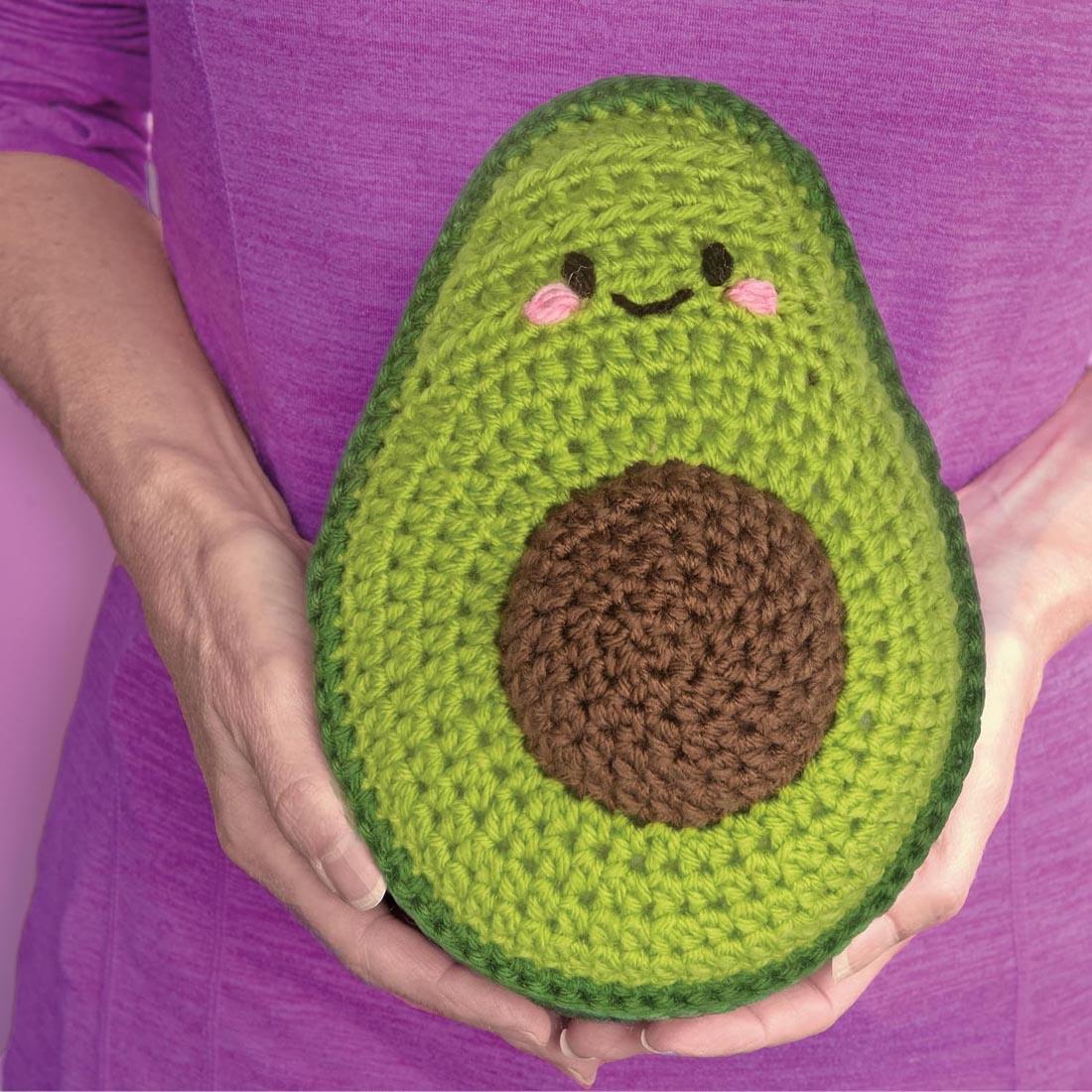 hands holding an example avocado made with the Learn To Crochet Avocado and Strawberry Kit