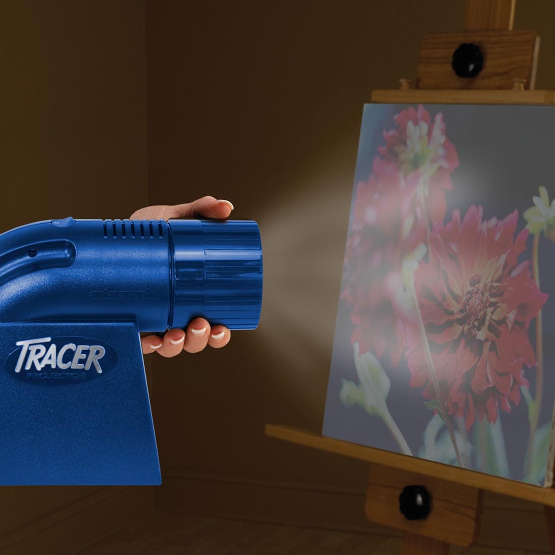 hand holding the Artograph LED Tracer Projector which is projecting onto a canvas