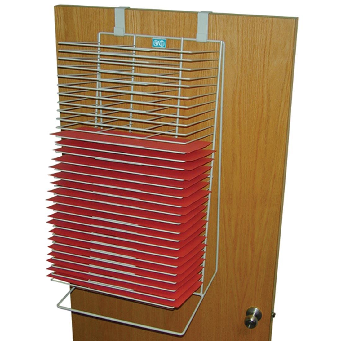 drying rack with red papers in it, hanging from a door
