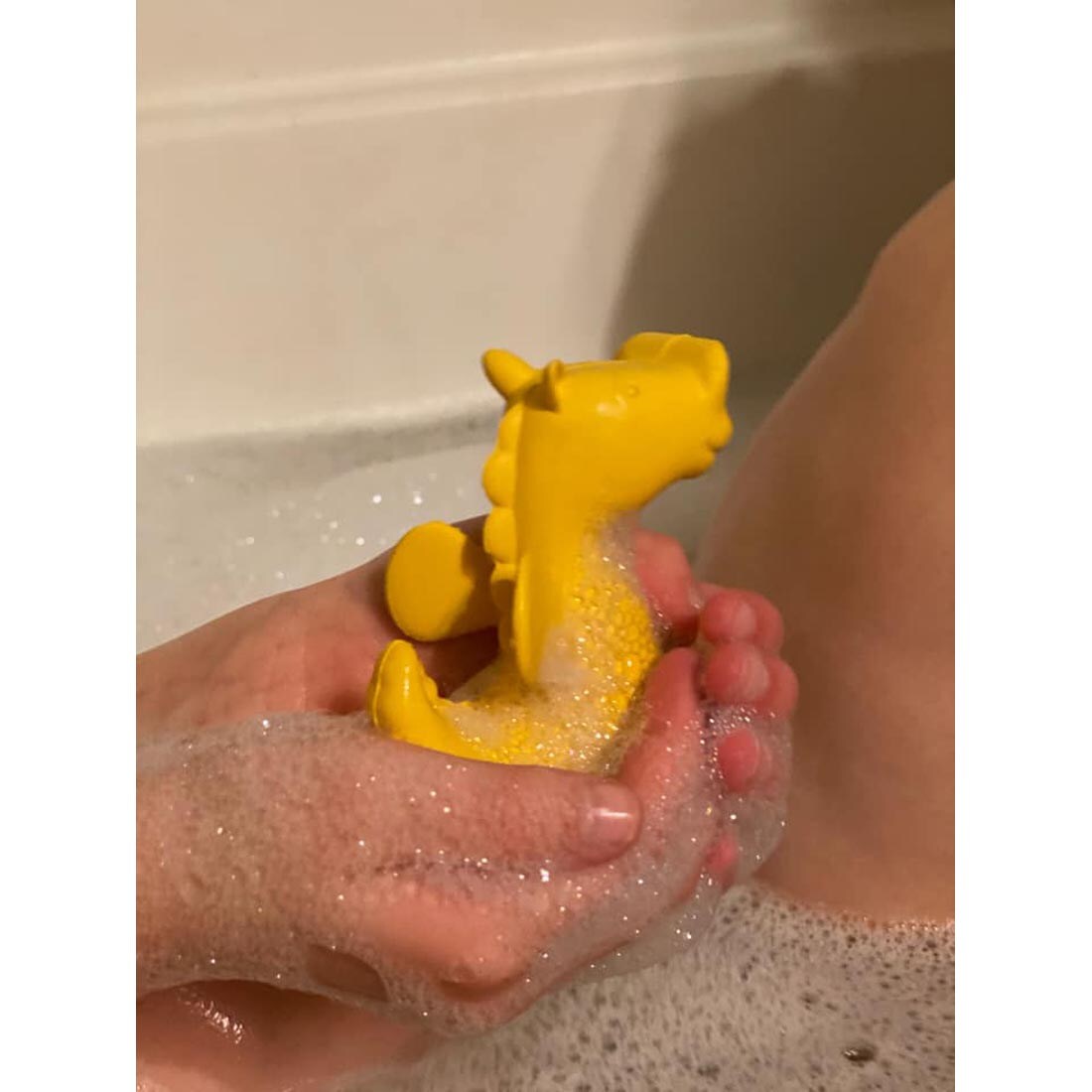 Sudsy hands holding Sea Horse Bathtub Pal by BeginAgain Toys