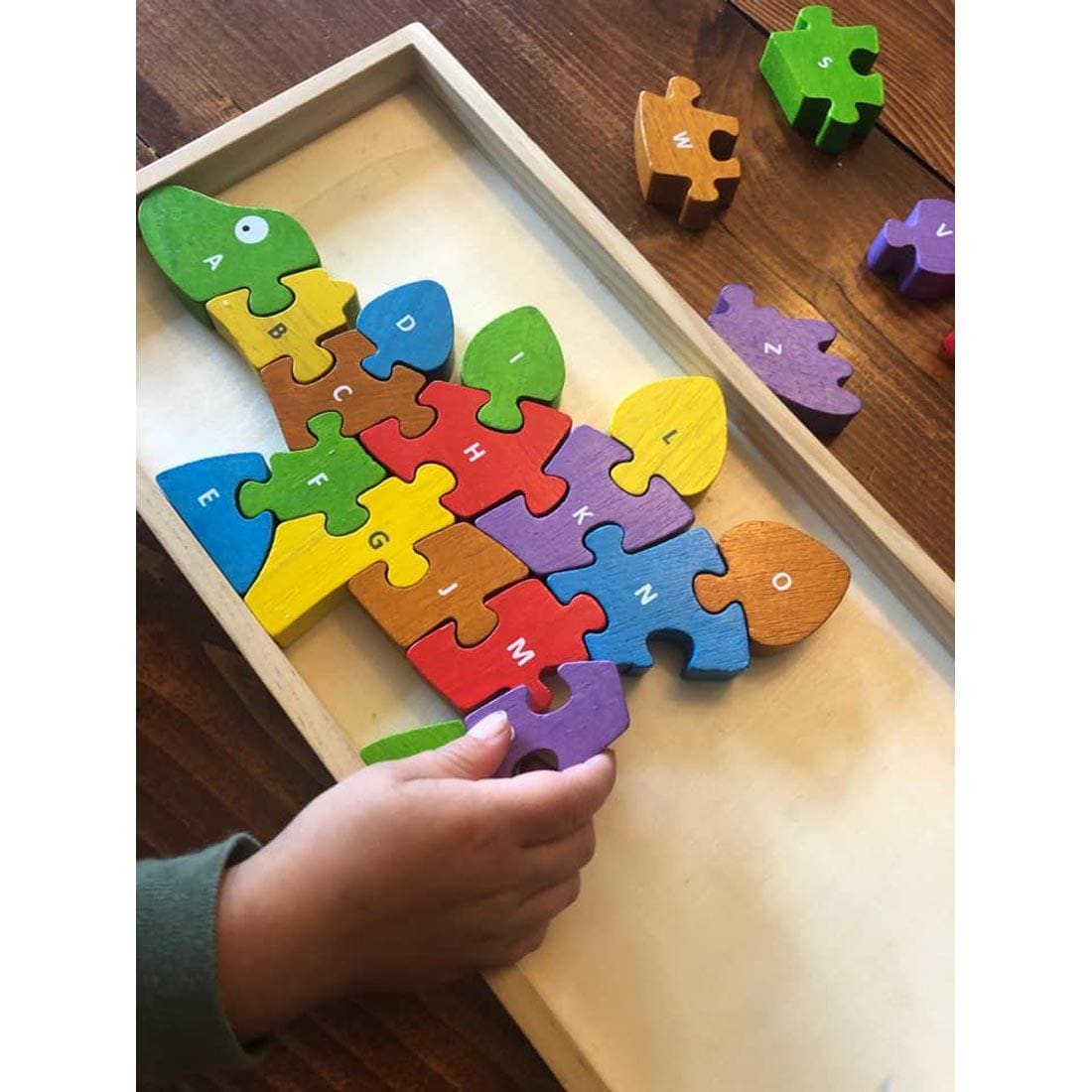 Dinosaur A To Z Puzzle being put together in its tray