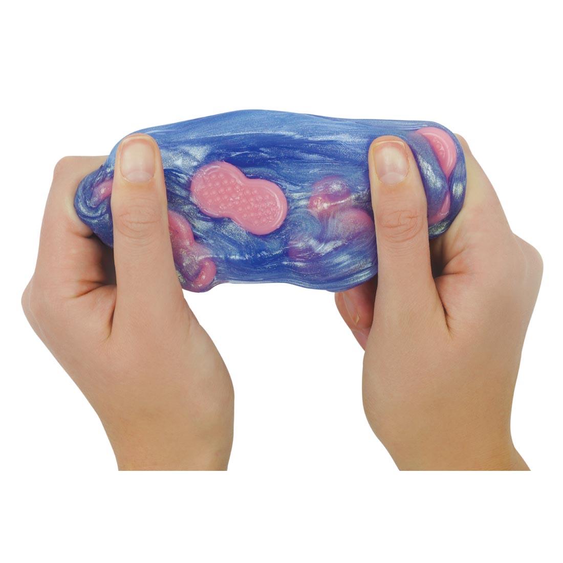 hands stretching No Worries Thinking Putty By Crazy Aaron to show the embedded silicone worry stones