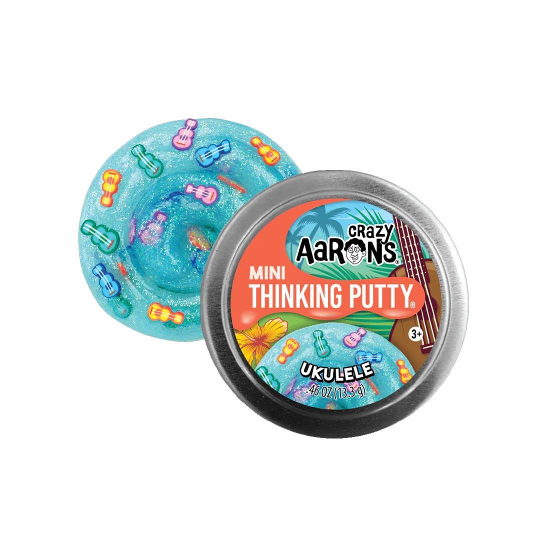 front of tin beside the Ukulele Mini Thinking Putty by Crazy Aaron