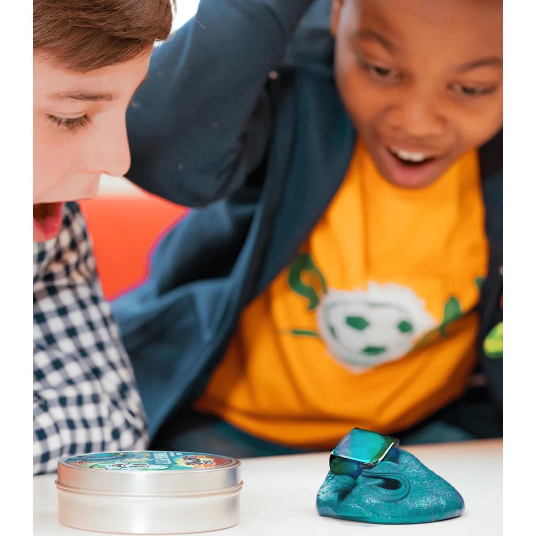 Two kids playing with Happy Earth Magnetic Thinking Putty by Crazy Aaron