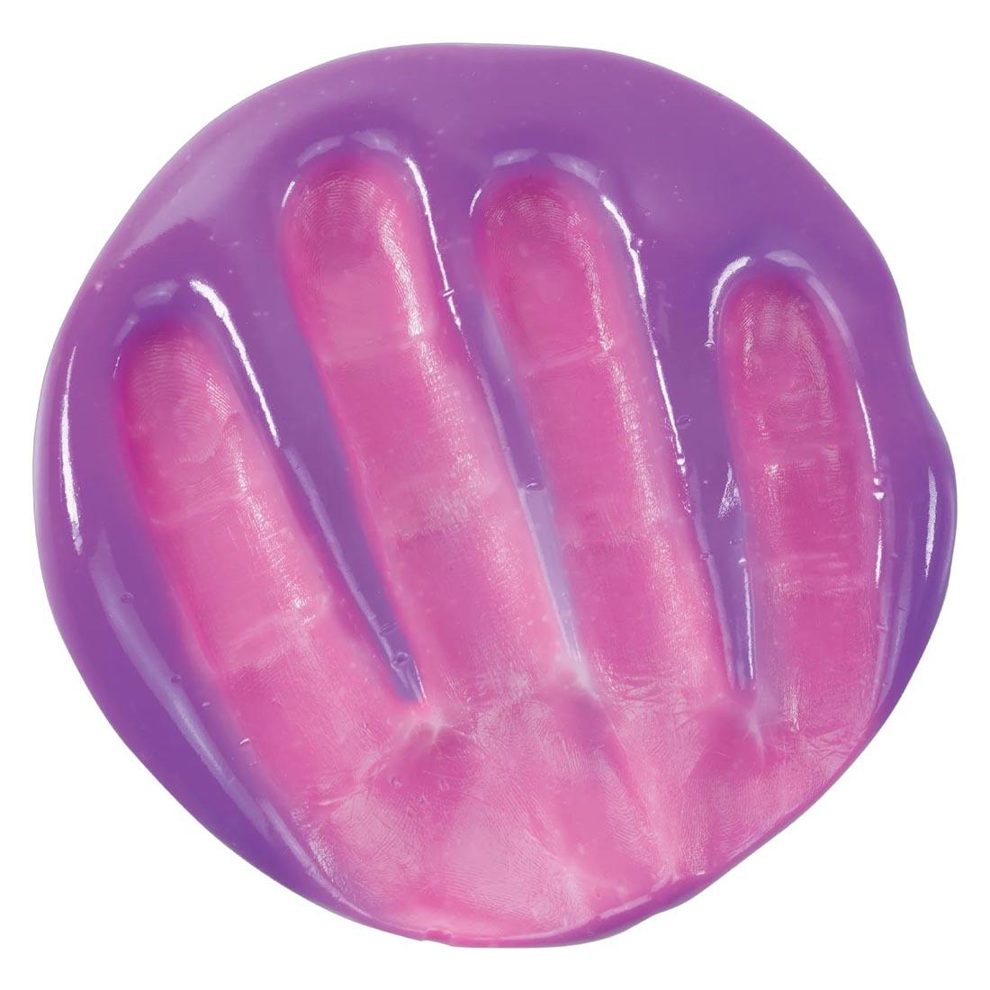 a hand pressed into Rainbow Reveal Thinking Putty by Crazy Aaron that's turning from purple to pink