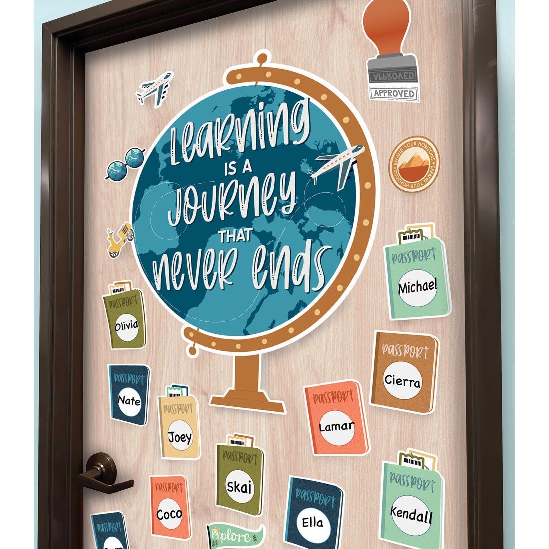 Example of how to display Let's Explore Learning Is a Journey Bulletin Board Set By Carson Dellosa in the classoom, shown on a door