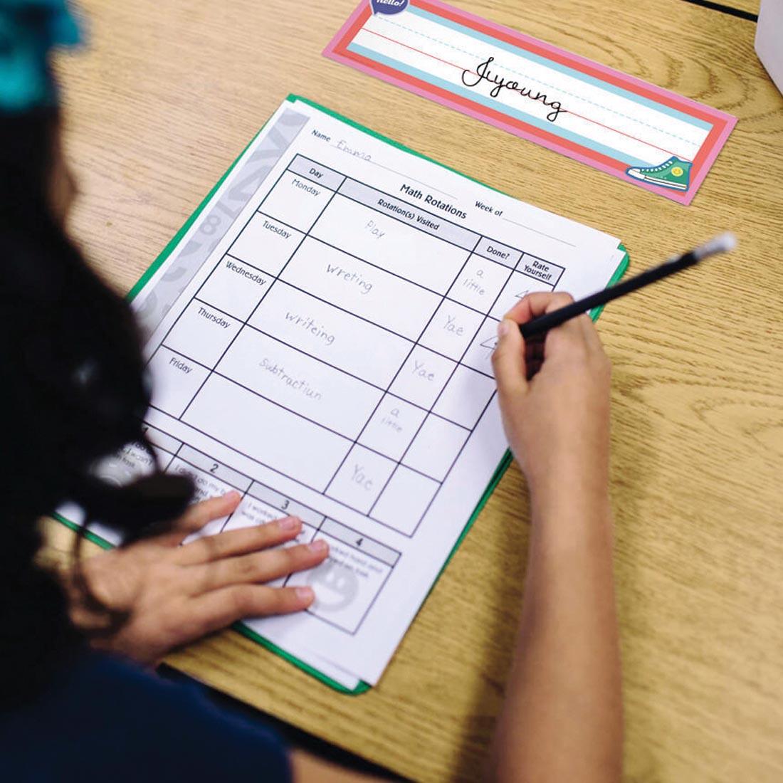 student at a desk labeled with a Name Plate from the We Stick Together collection by Carson Dellosa