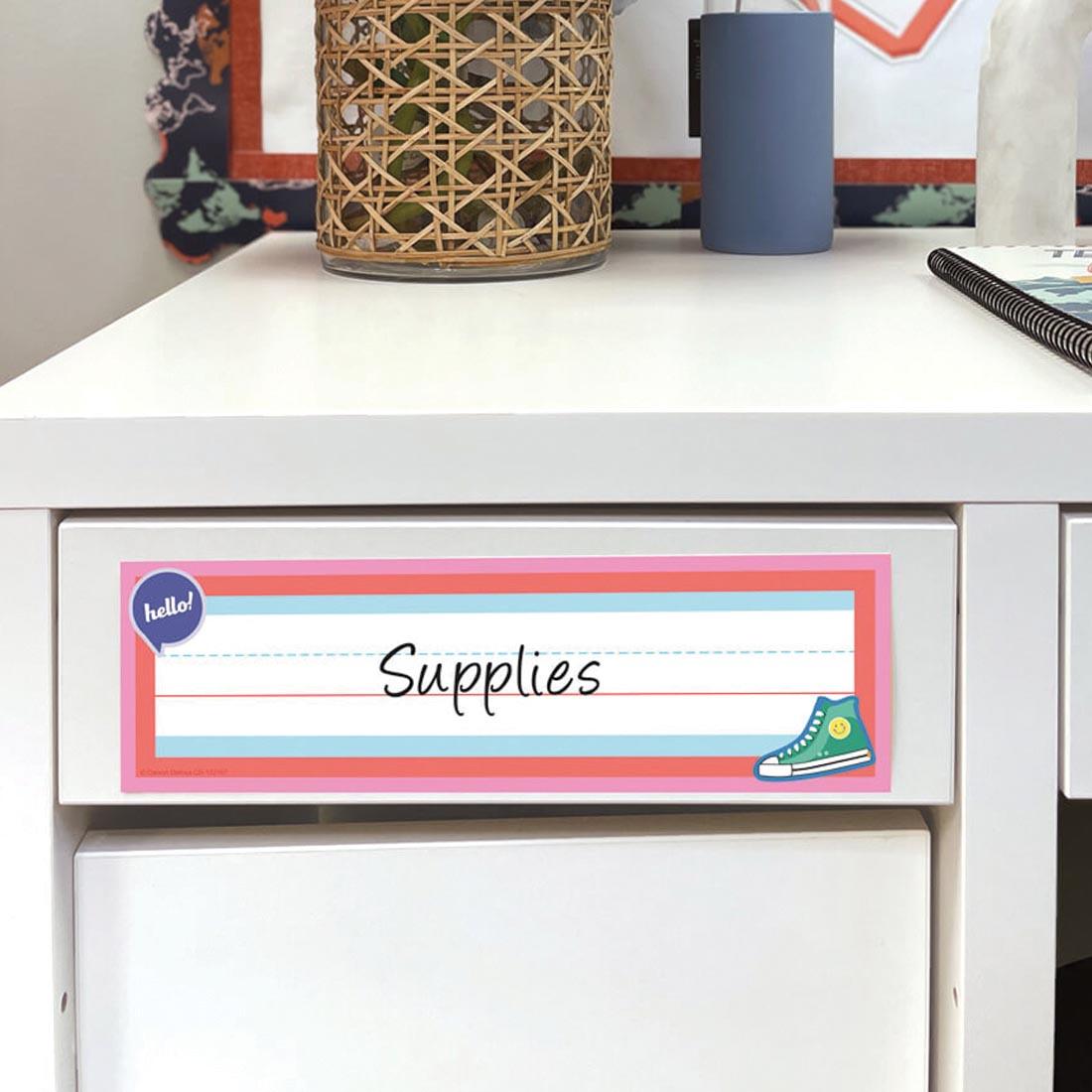 cabinet labeled Supplies using a Name Plate from the We Stick Together collection by Carson Dellosa