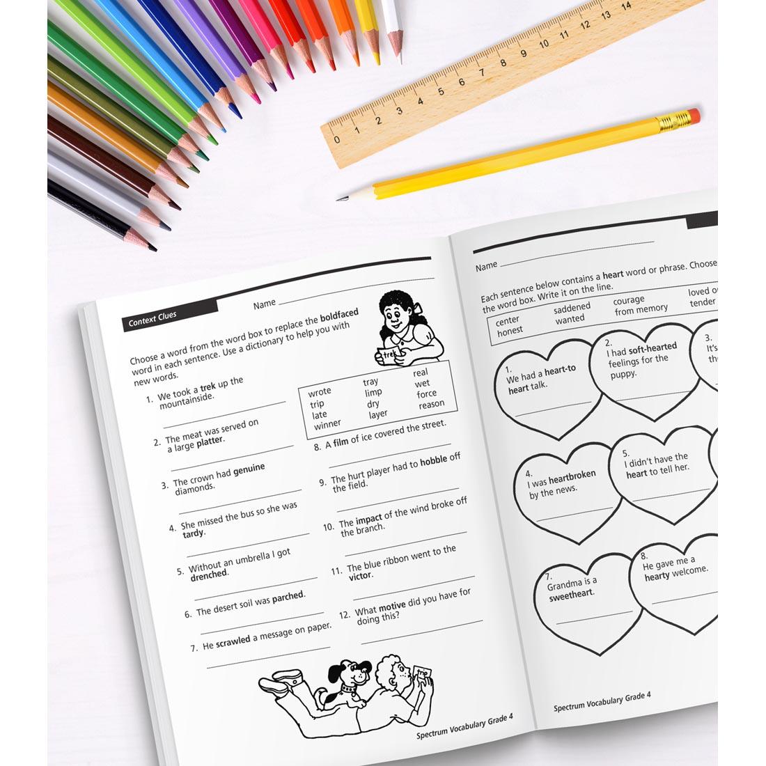 open book of Spectrum Vocabulary for Grade 4 along with colored pencils, a ruler and a pencil