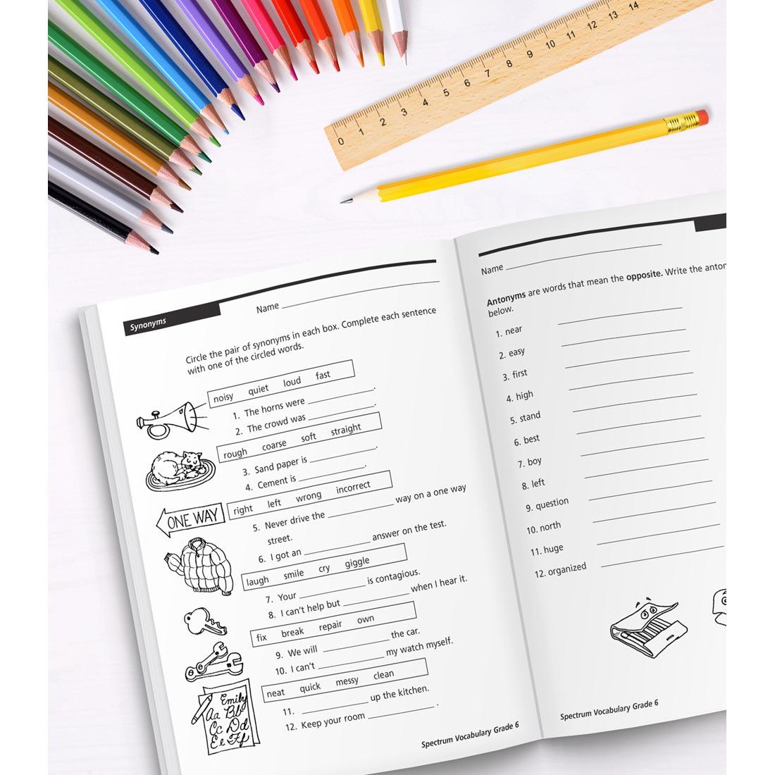 open book of Spectrum Vocabulary for Grade 6 along with colored pencils, a ruler and a pencil