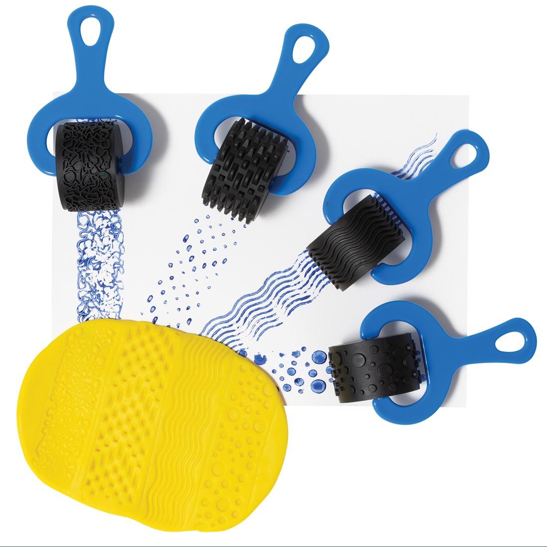 4 dough/paint rollers showing what patterns look like when used with yellow dough and blue paint