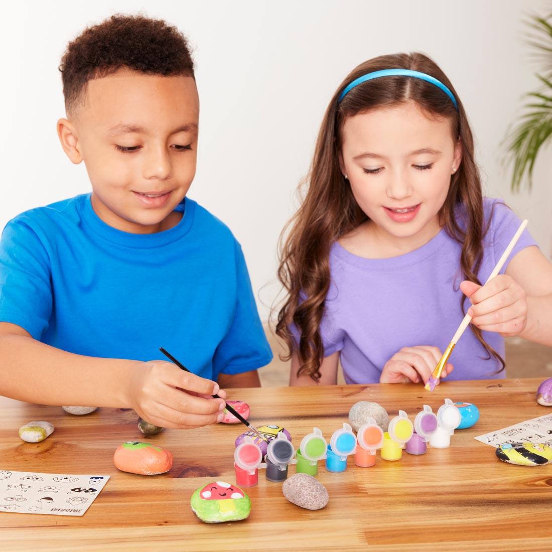Two children painting rocks with the Hide & Seek Rock Painting Kit by Creativity For Kids