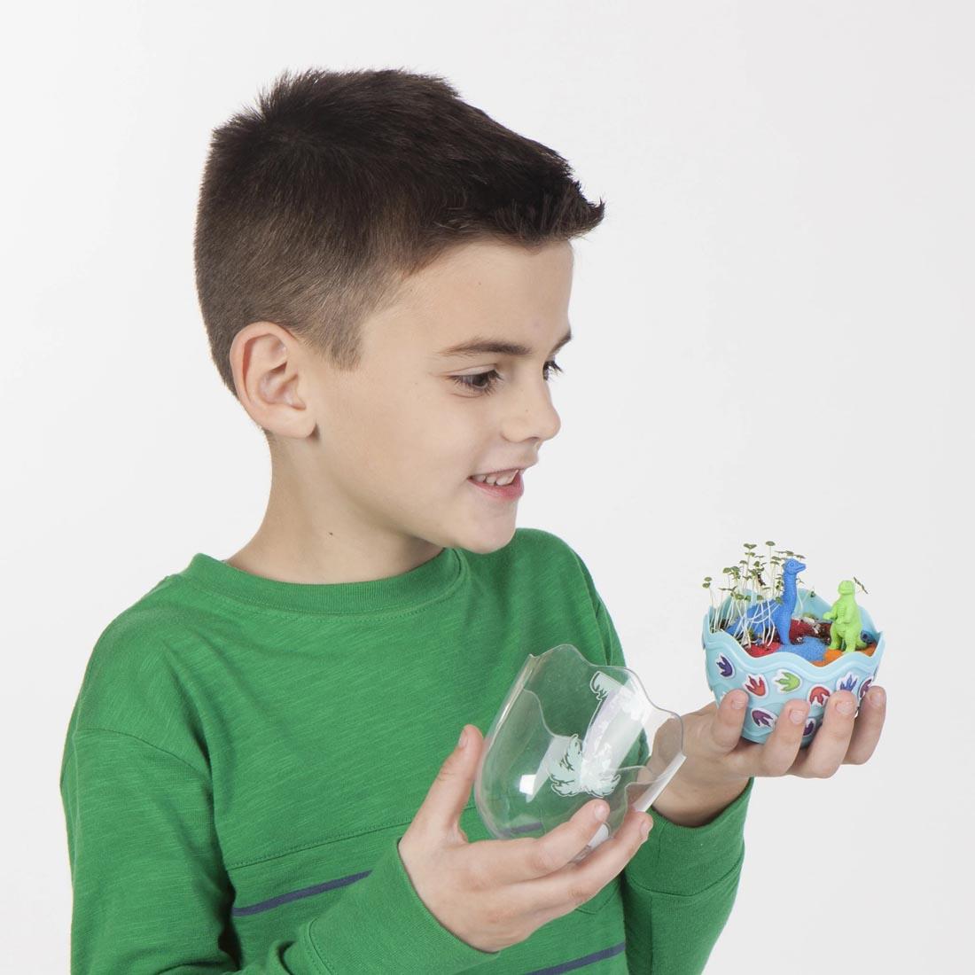 Child holding a Dinosaurs Mini Garden By Creativity For Kids