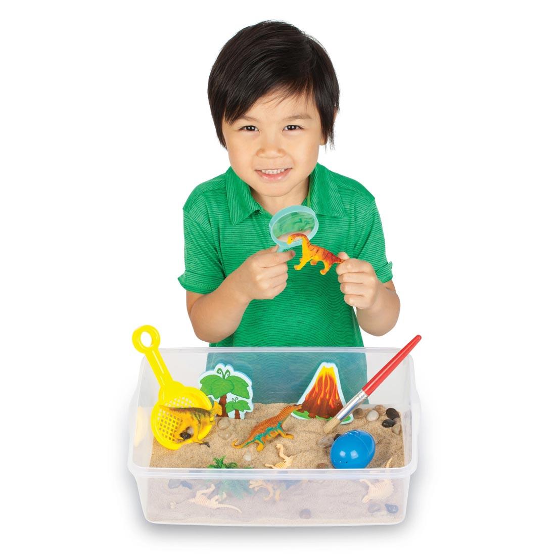 Child playing with the Dinosaur Dig Sensory Bin By Creativity For Kids