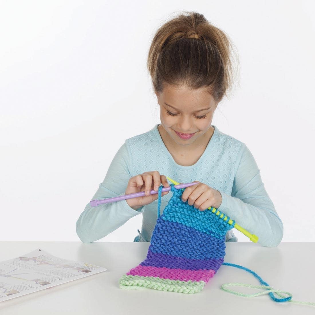 Child knitting the Learn To Knit Pocket Scarf Kit By Creativity For Kids