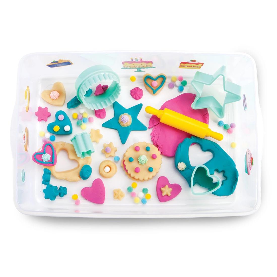 open tub of Bake Shop Sensory Bin By Creativity For Kids with components and clay creations made