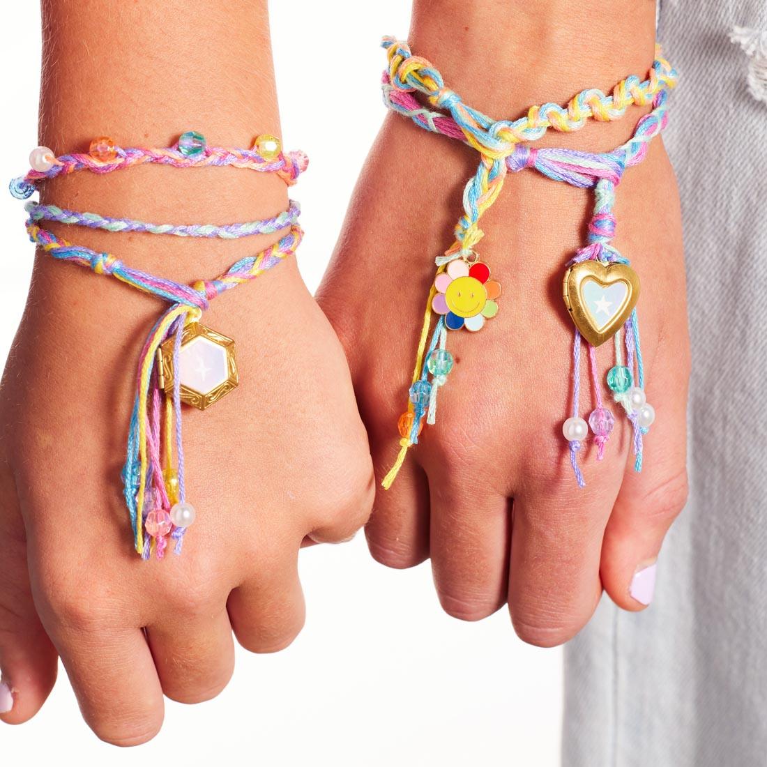 two wrists wearing completed examples from the Friendship Bracelets Kit By Creativity For Kids