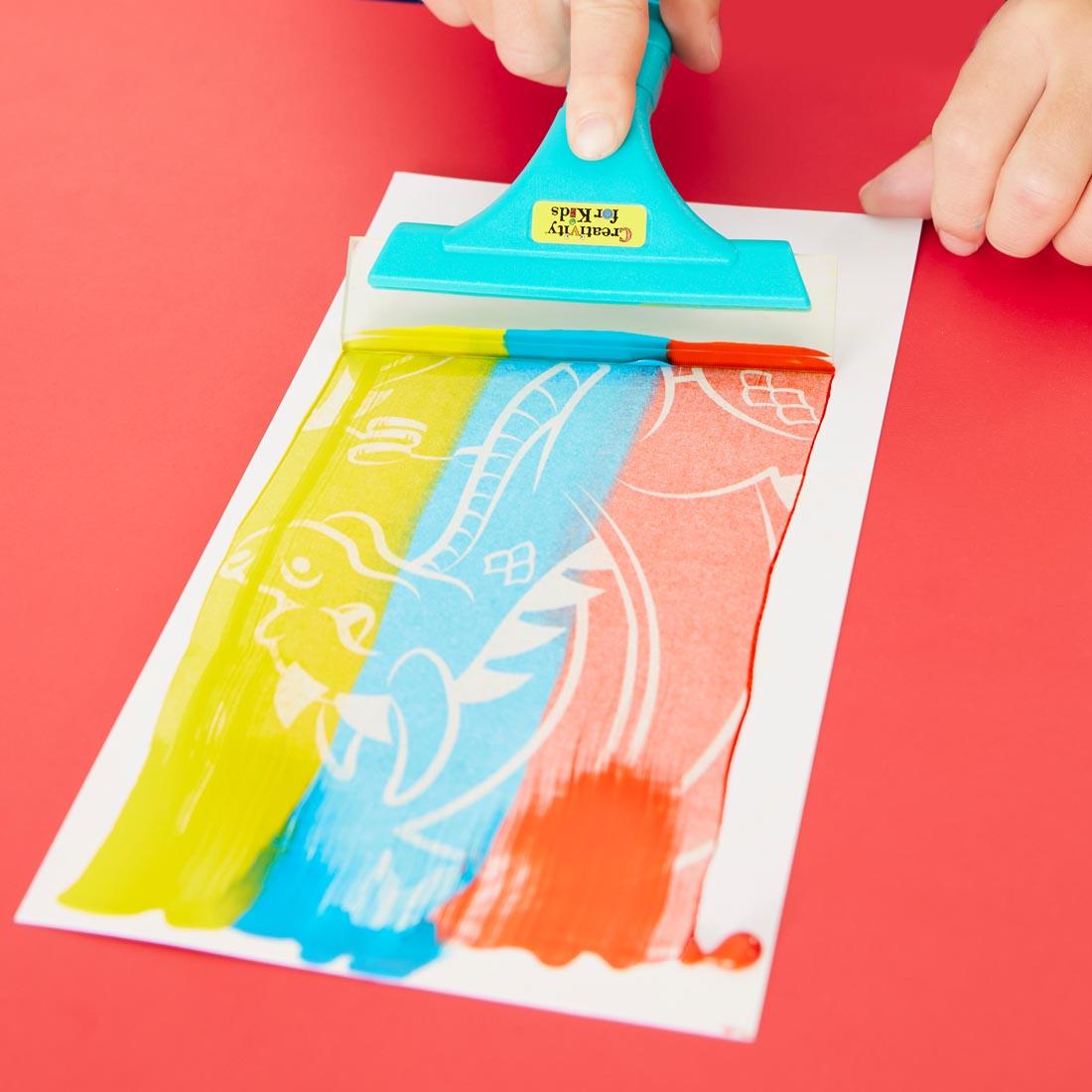 hand using squeegee from Squeegeez Magic Reveal Art Dragon set