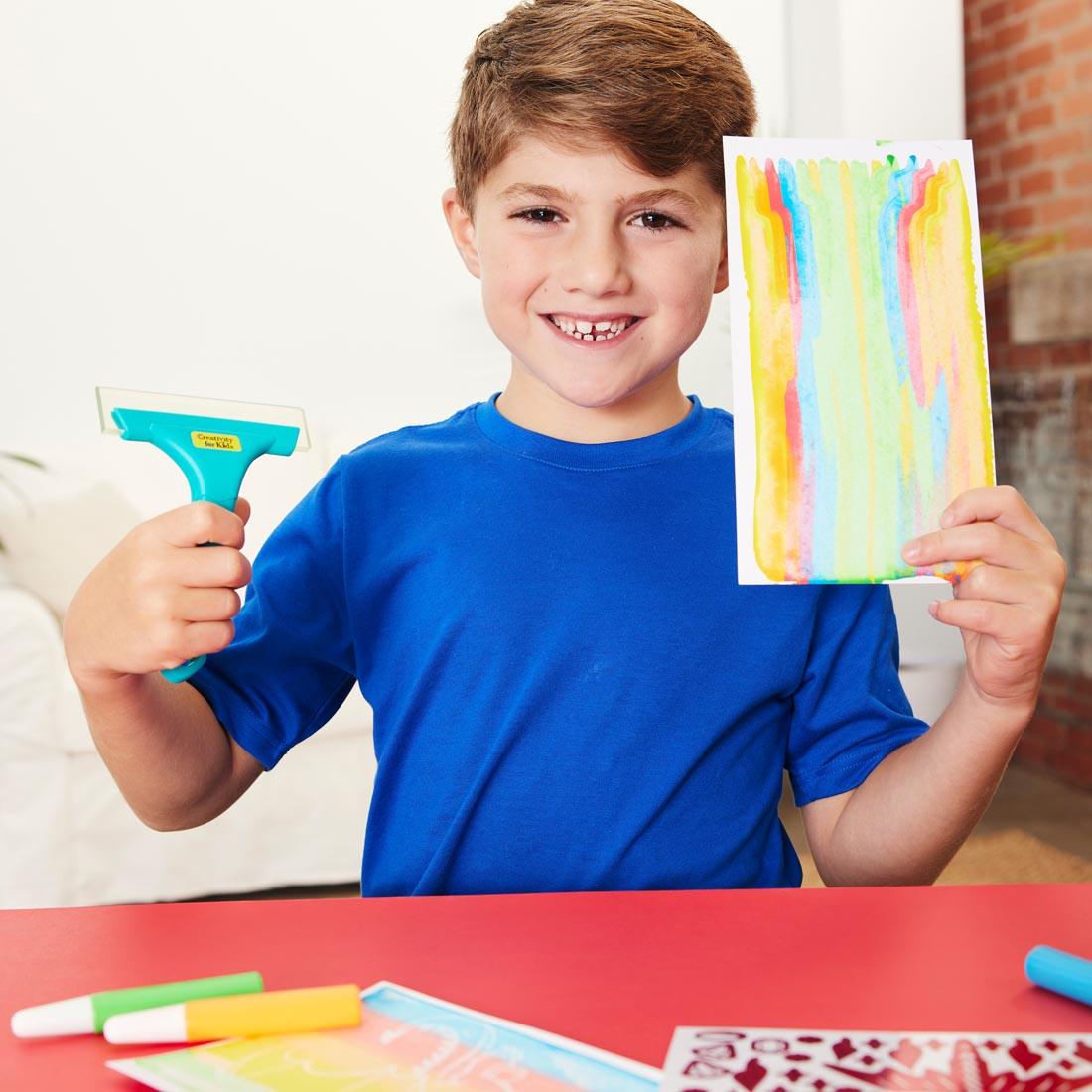 child holding squeegee and art from Squeegeez Magic Reveal Art Dragon set