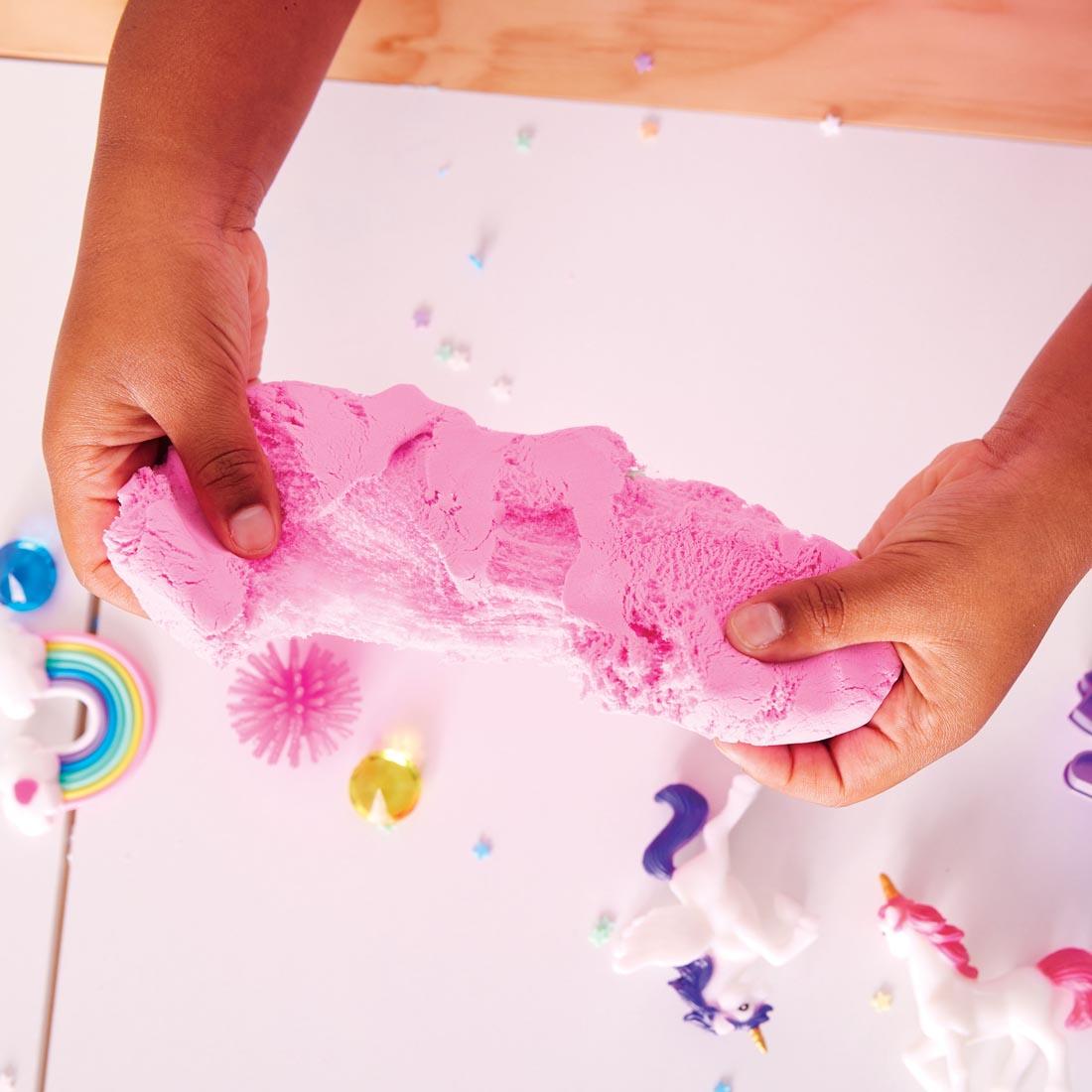 child's hands holding clay from the Unicorn Sensory Pack By Creativity For Kids