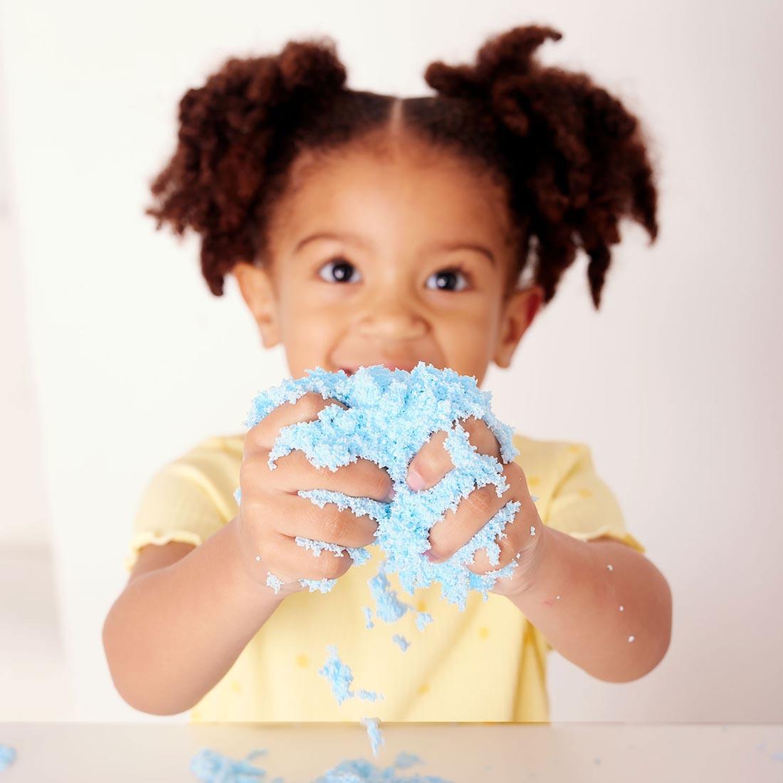 child holding sand from the Mermaid Sensory Bin
