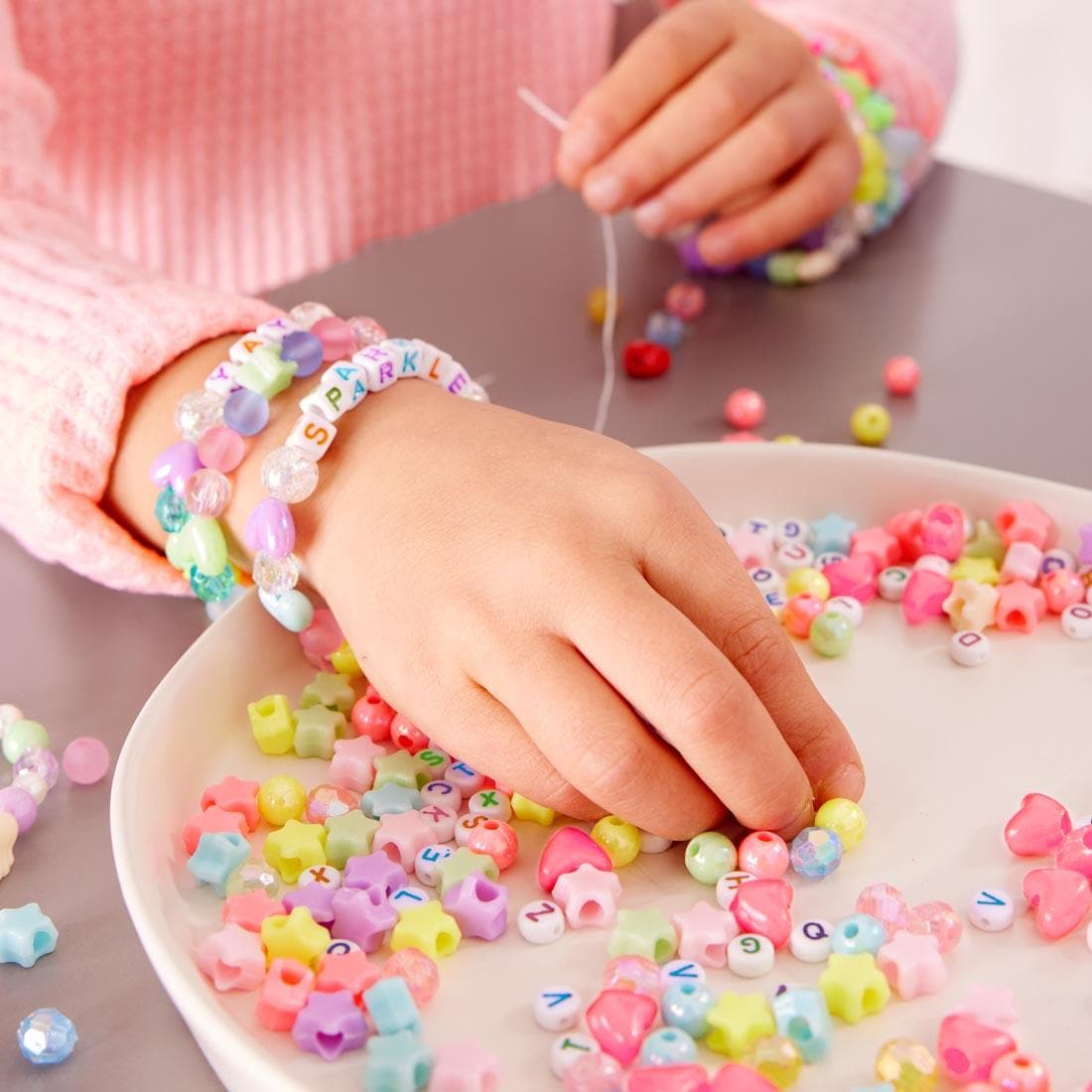 child's hands using beads from the Unicorn Bead Jewelry Jar
