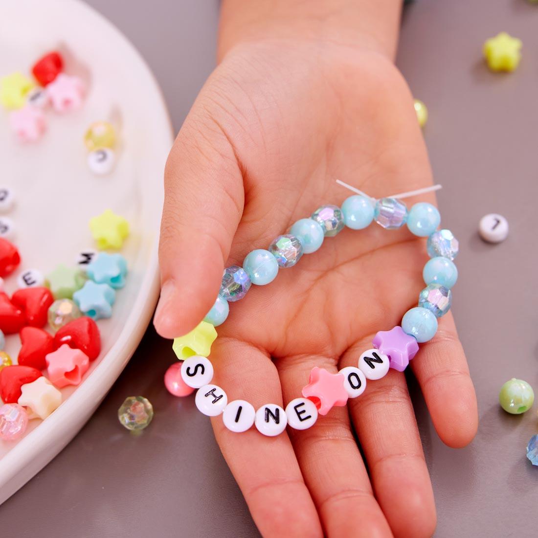 hand holding a bracelet made with beads from Rainbow Bead Jewelry Jar By Creativity For Kids