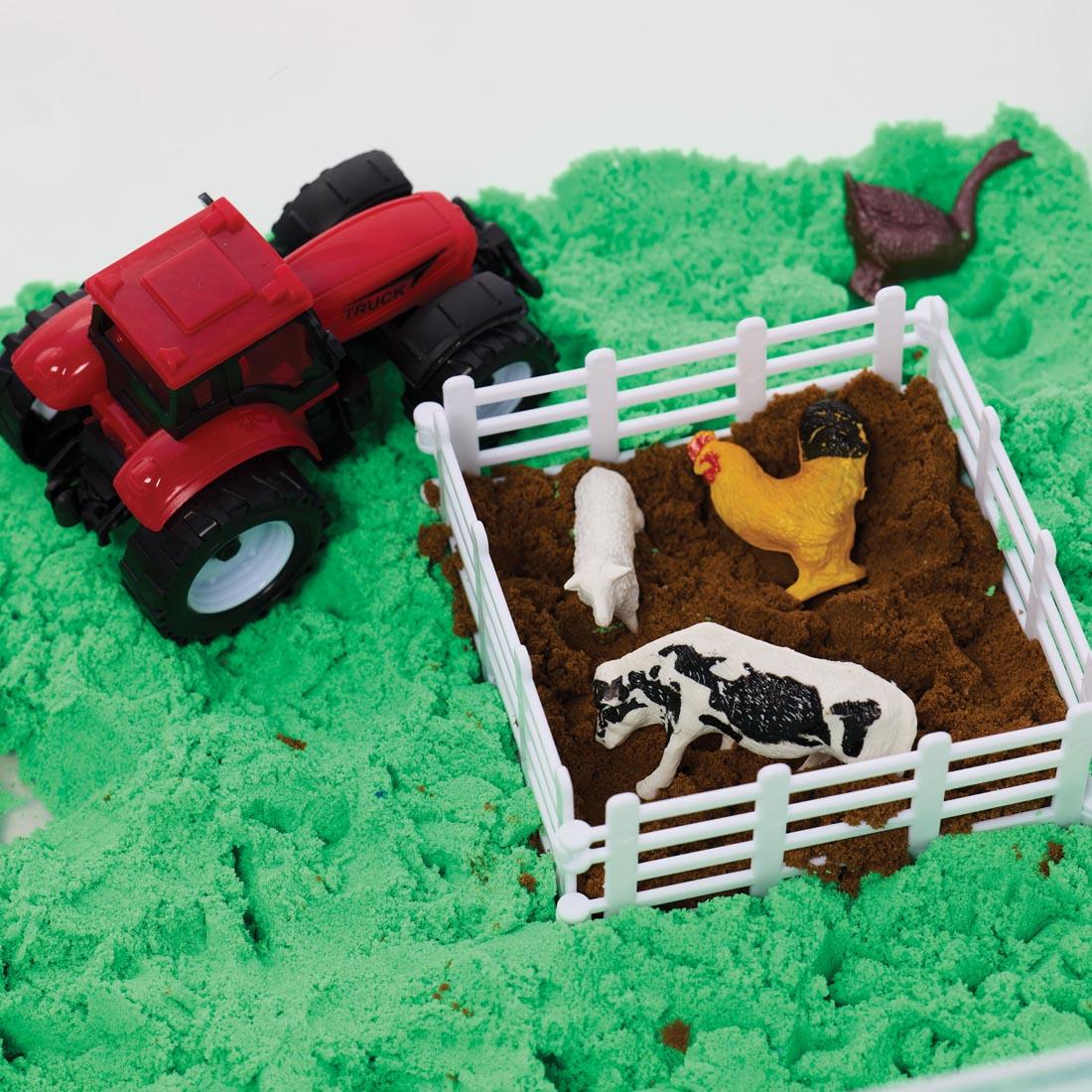 close up of Farm Sensory Bin, showing animals in a pen, plus a tractor