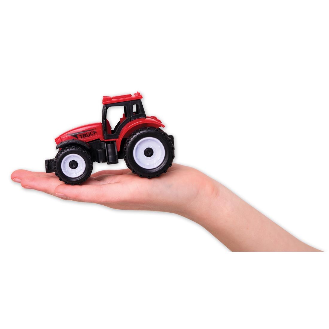 open hand holding the tractor found in the Farm Sensory Bin