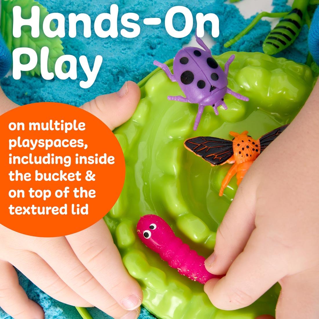 hand playing with Neon Bugs Sensory Adventure set, with the words: Hands-On Play on multiple playspaces, including in the bucket and on the textured lid