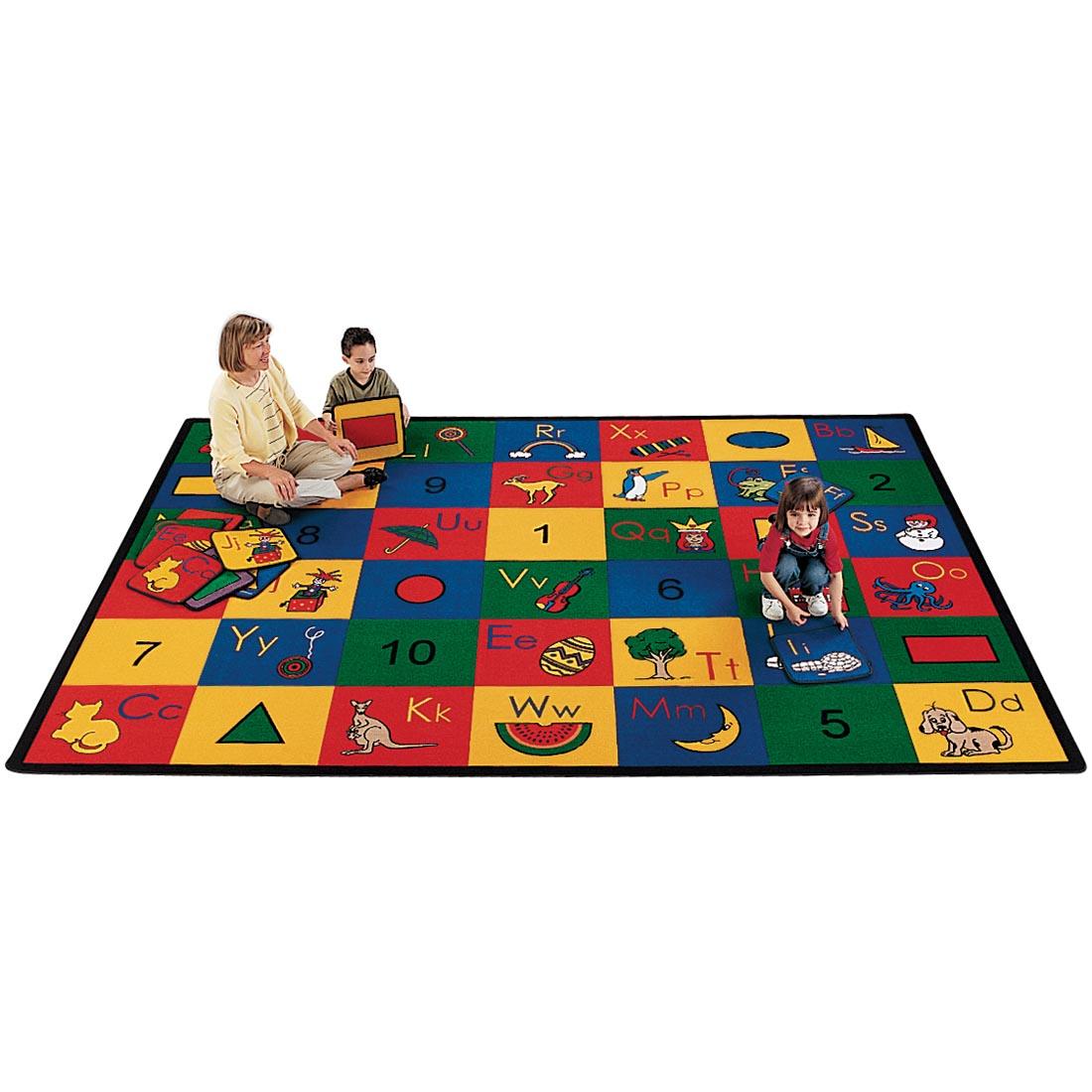 Children matching the squares of the Blocks of Fun Rectangle Rug by Carpets For Kids