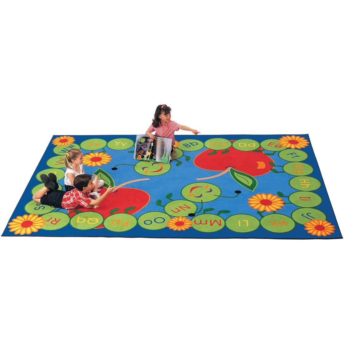 Children sitting and laying on the ABC Caterpillar Rectangle Rug by Carpets For Kids