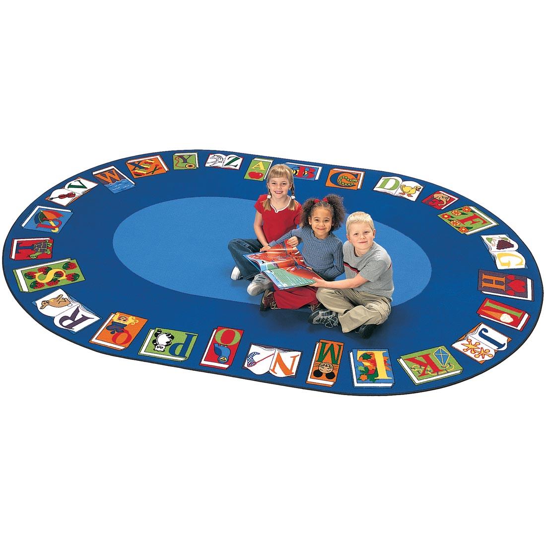 Children with a book sitting on the Reading by the Book Oval Rug by Carpets For Kids