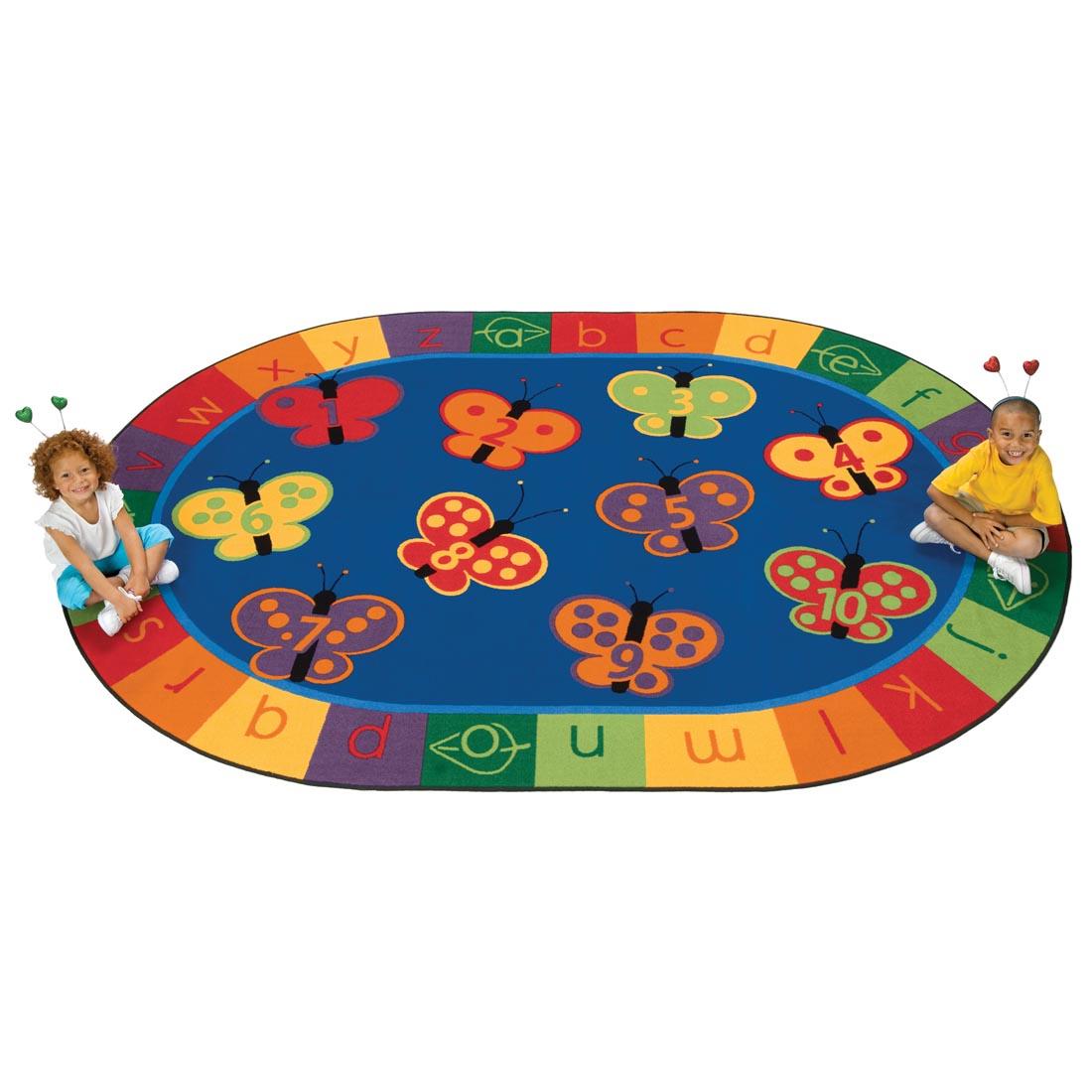 Children sitting on the 123 ABC Butterfly Fun Oval Rug by Carpets For Kids