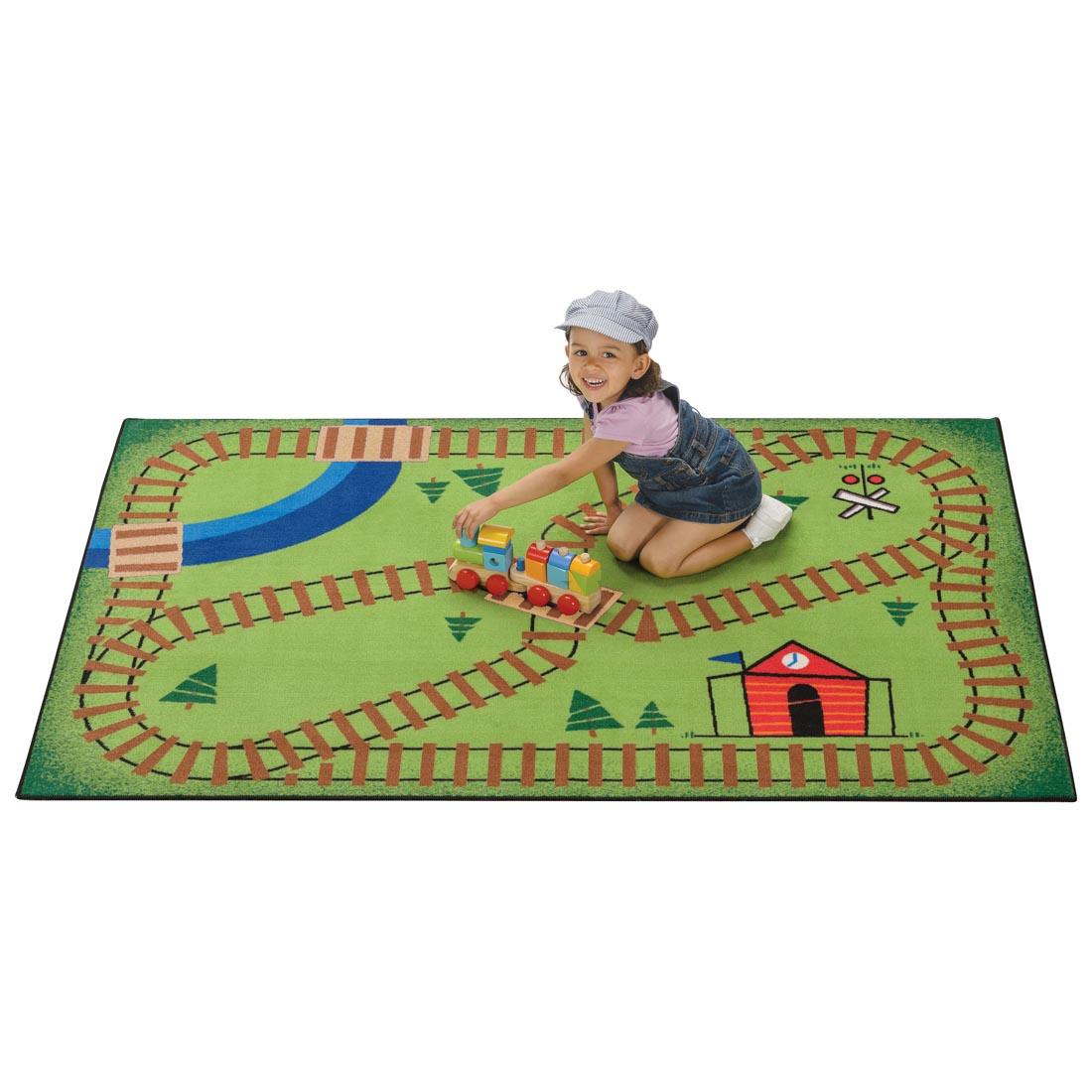 Railroad Playtime Kids Value Rug by Carpets For Kids with young girl playing on the rug with a wooden toy train
