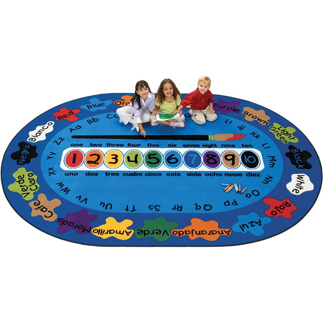 Children sitting on the Bilingual Paint by Numero Rug by Carpets For Kids