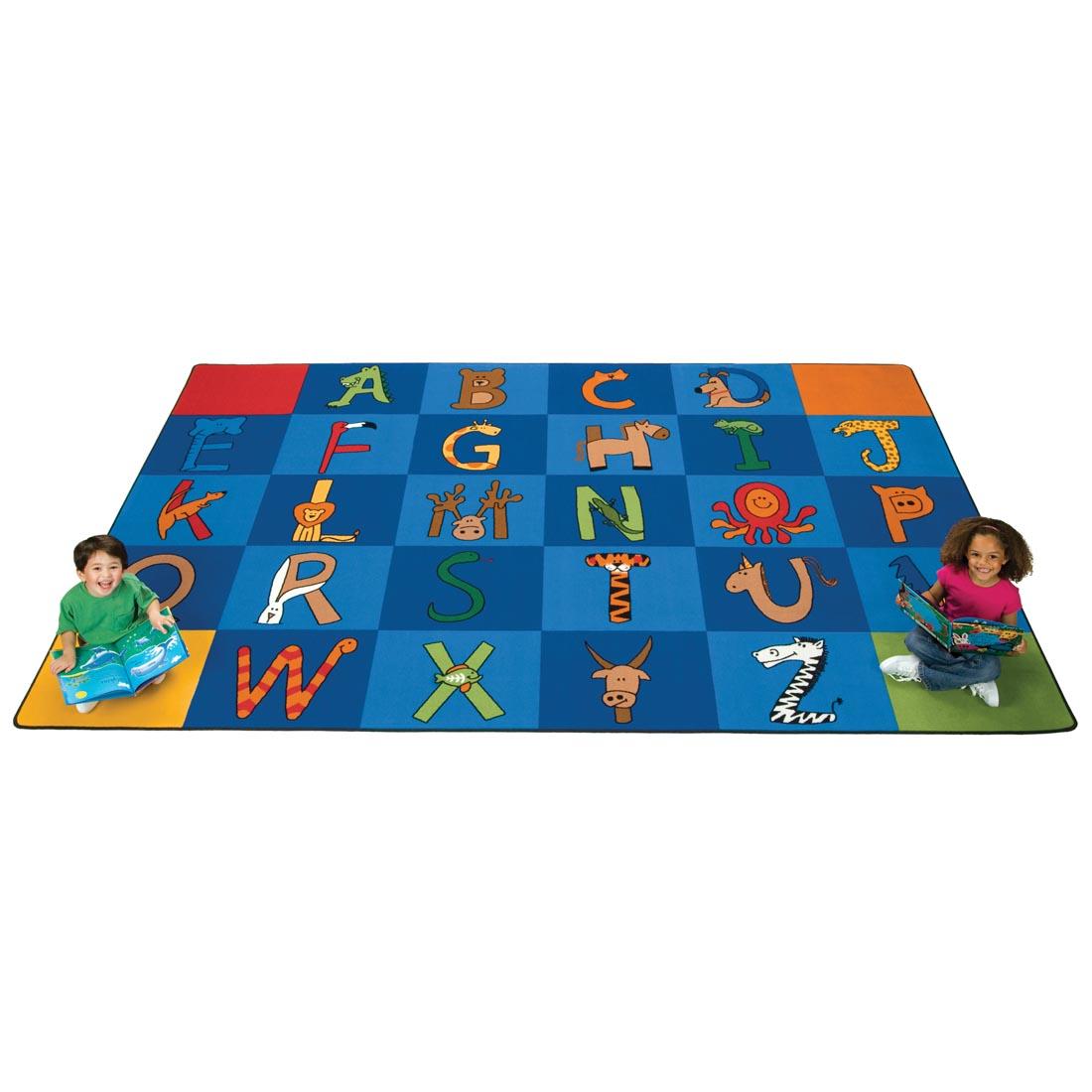 Children with books sitting on the A to Z Animals Rectangle Rug by Carpets For Kids