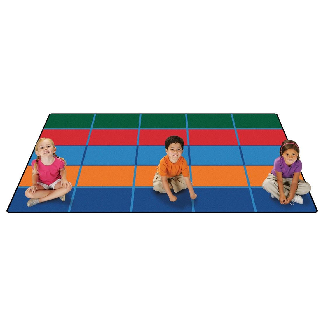 Color Blocks Seating Kids Value Plus Rug by Carpets For Kids with 3 young children sitting on the rug