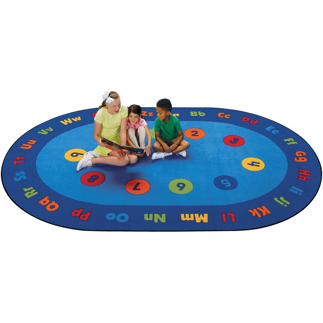 Circletime Early Learning Kids Value Plus Rug by Carpets For Kids with 3 children on the rug, looking at a book