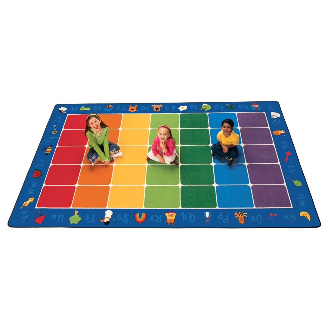 Fun With Phonics Rectangle Rug by Carpets For Kids, with 3 children sitting on 3 different colored squares