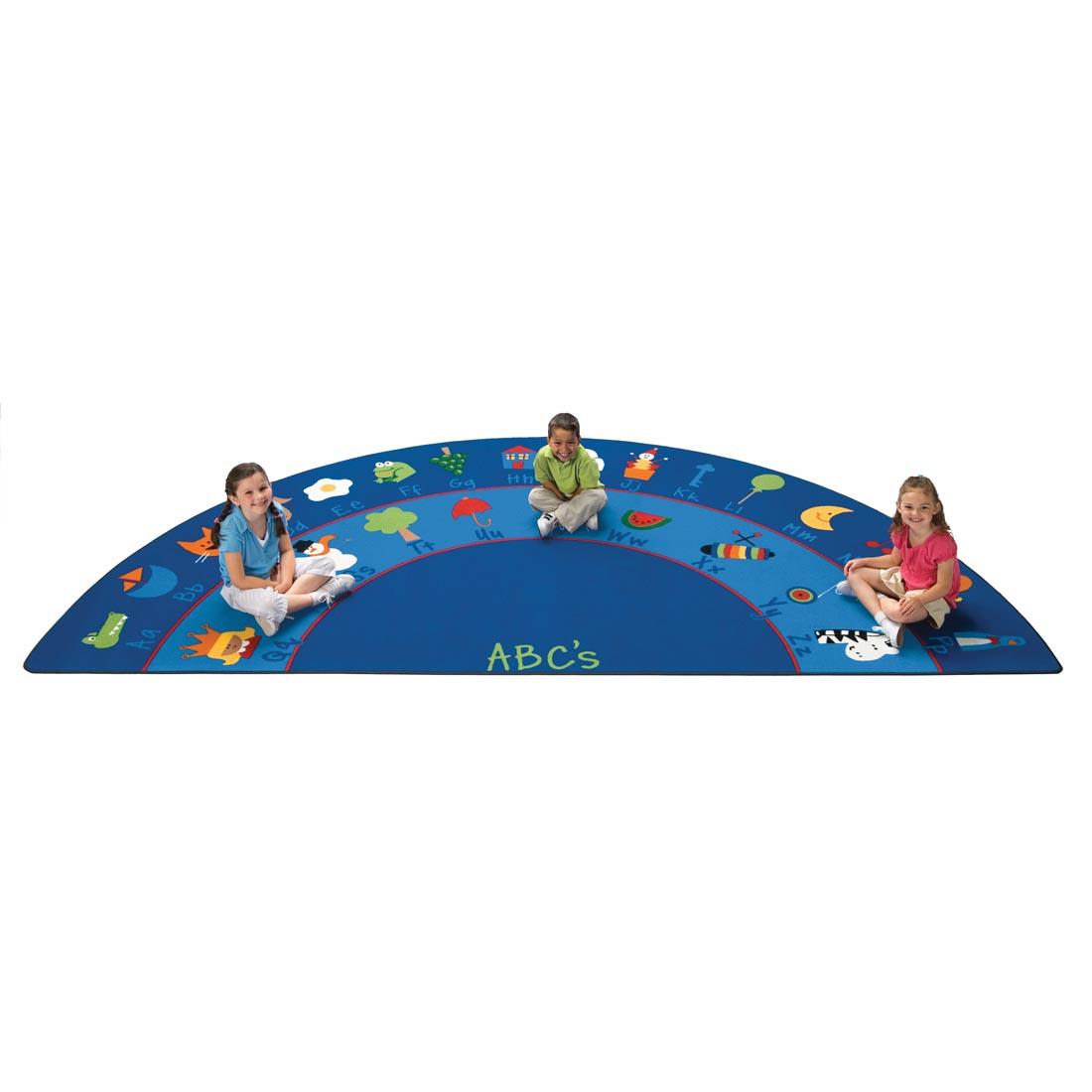 Three children sitting on the Fun With Phonics Semi-Circle Rug by Carpets For Kids