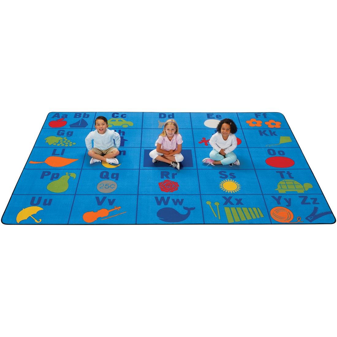 Alphabet Seating Rug by Carpets For Kids, with 3 children sitting on the rug