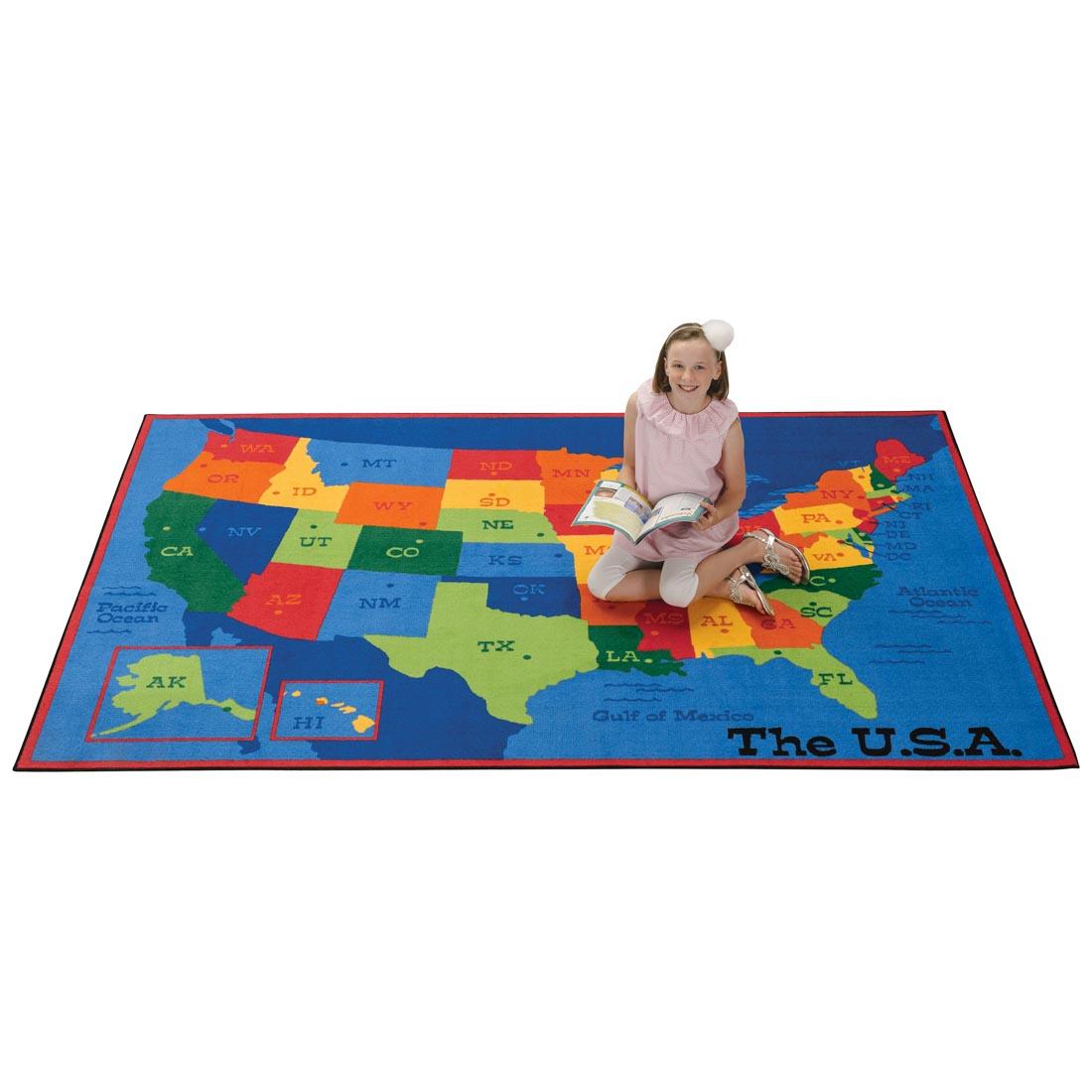 USA Map Kids Value Plus Rug by Carpets For Kids with girl kneeling on the rug, holiding a book