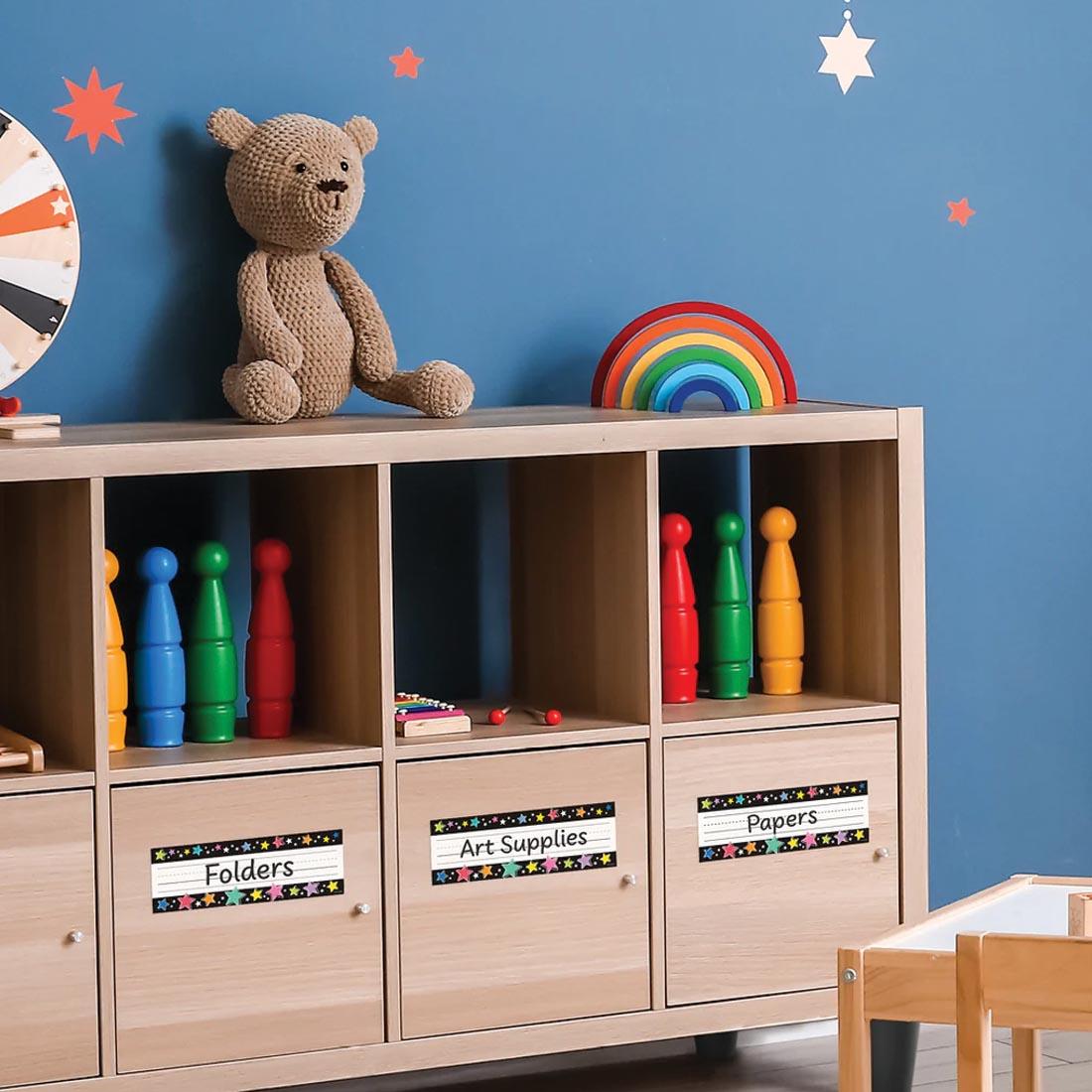 Storage cabinets labeled with Folders, Art Supplies, Papers using Colorful Stars on Black Name Plates from the Star Bright collection by Creative Teaching Press